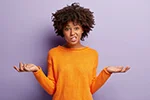 A confused woman wearing an orange sweater looking at you